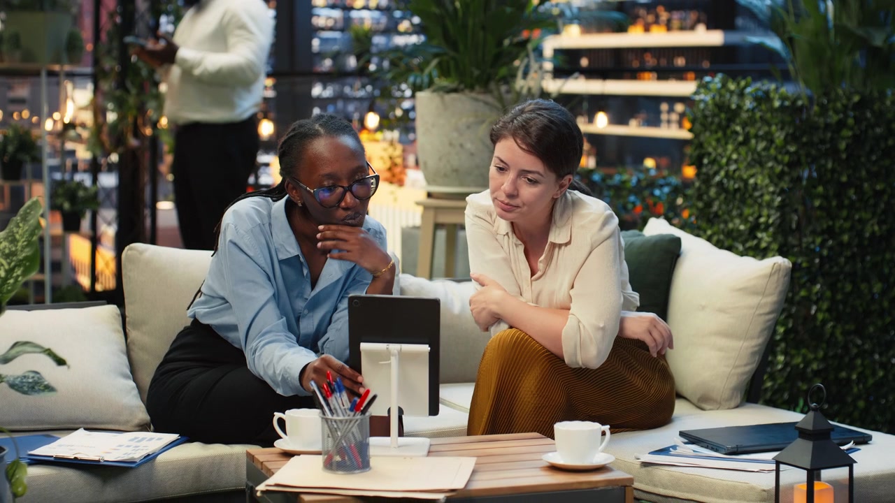 Businesswomen discussing tablet information on rooftop terrace