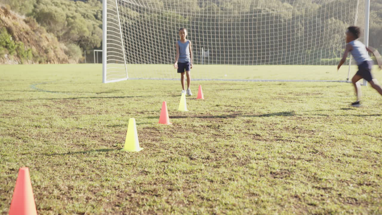 Practicing soccer drills, kids running through cones on school field