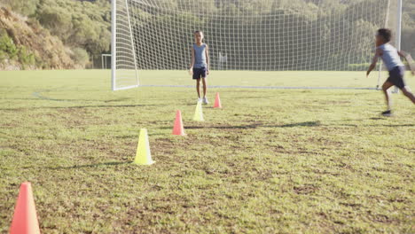 practicing soccer drills, kids running through cones on school field