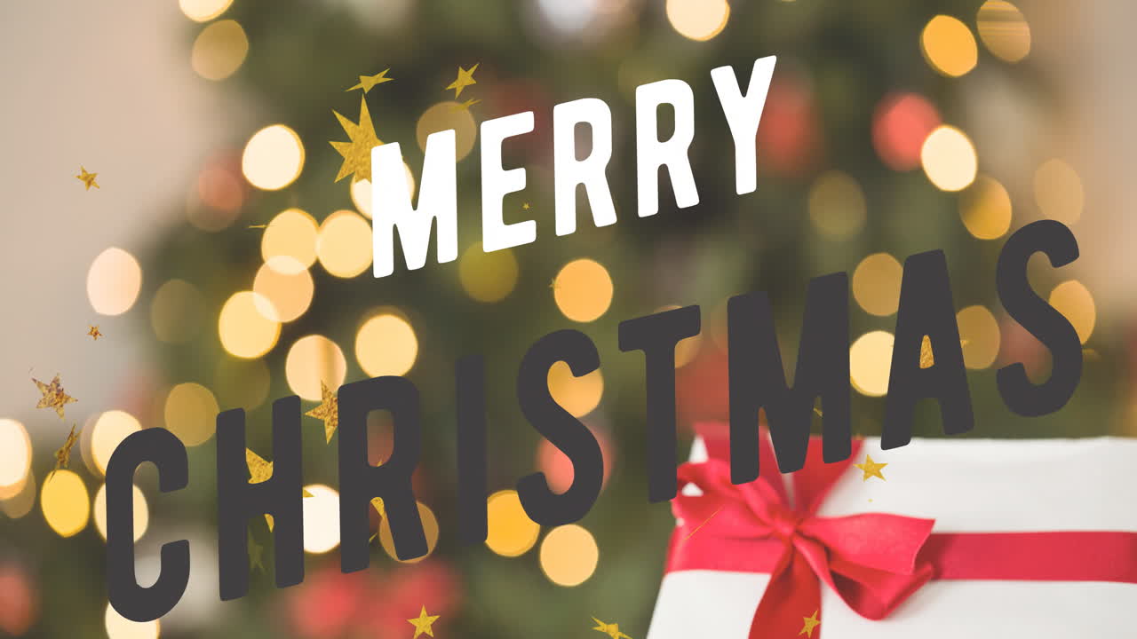 Merry Christmas text animation over blurred Christmas tree with lights and gift box