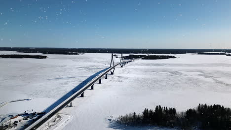 aérea, nieve cayendo en el puente de replot y paisaje de invierno en ostrobotnia finlandia