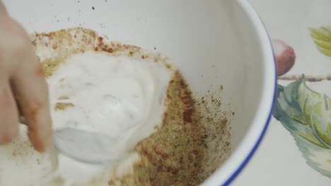 Adding-spices-to-butter-milk-inside-white-deep-plate