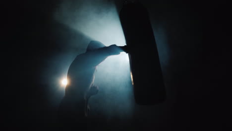 fighter's silhouette trinity in the gym - hits a boxing pear