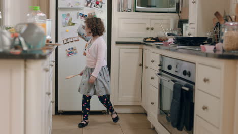 happy little girl dancing in kitchen having fun doing funny dance moves enjoying weekend at home