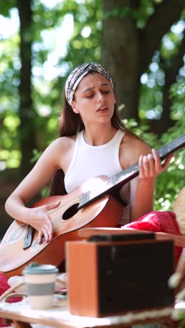 woman playing acoustic guitar in a park