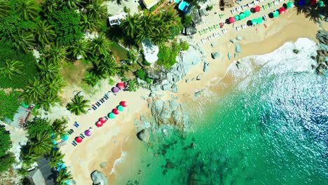 a drone view of vibrant umbrellas, golden sand, and turquoise waves—this hidden thai beach blends chaos and calm in perfect tropical harmony.