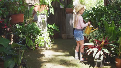 Little-girl-gardening-and-watering-plant-in-a-botanical-garden