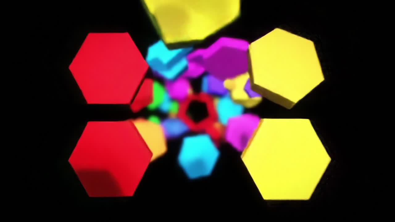 Dynamic Movement of Colorful Geometric Shapes Appearing to Spiral in a Dark Background, Creating a Vivid Visual Experience of 3D Animation