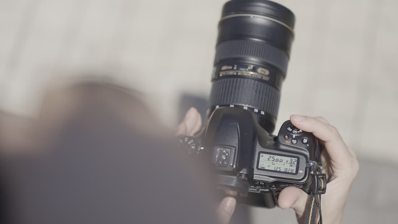 Persona che tiene una fotocamera DSLR