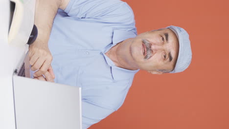 Vertical-video-of-Tired-old-man-at-laptop.