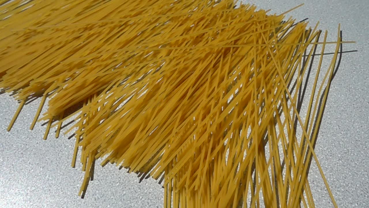 Espaguetis cayendo sobre una mesa. Cámara lenta.