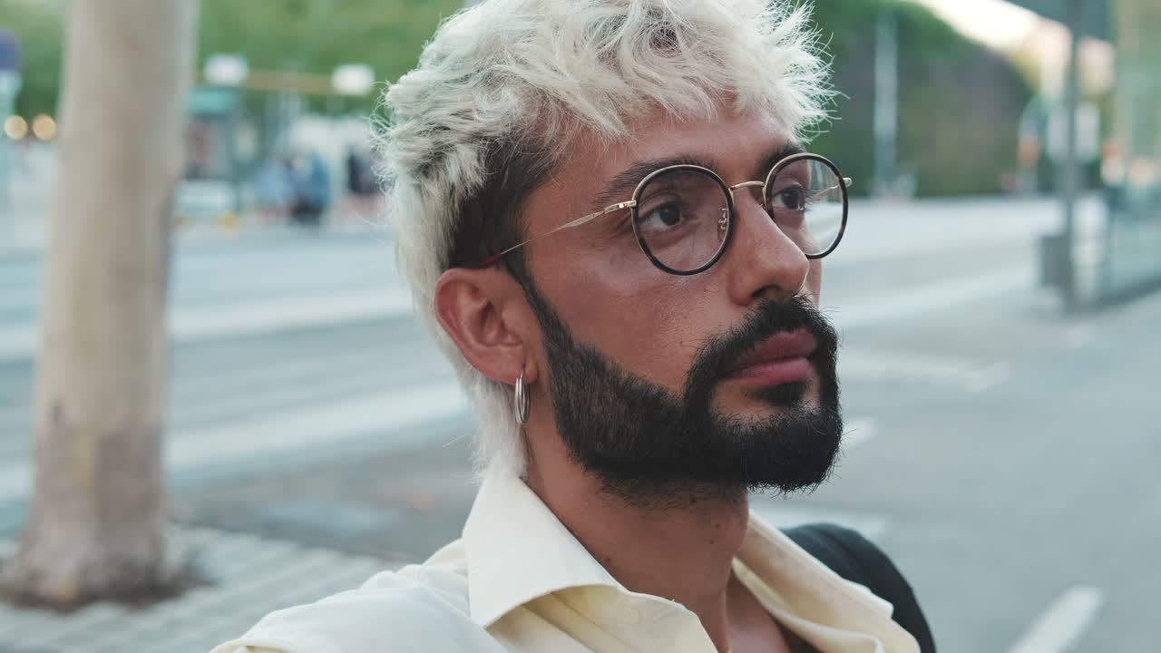 Young Man with Bleached Hair and Glasses Looking Around in City