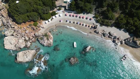 drone top down bird's eye view of skiff anchored at entrance to luxury beach bay