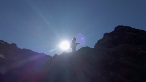 excursionista apuntando a la distancia en la cima de la montaña de ángulo bajo kananaskis alberta canada