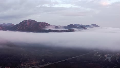 aerial - low clouds above a mountain village at lake skadar, montenegro, forward