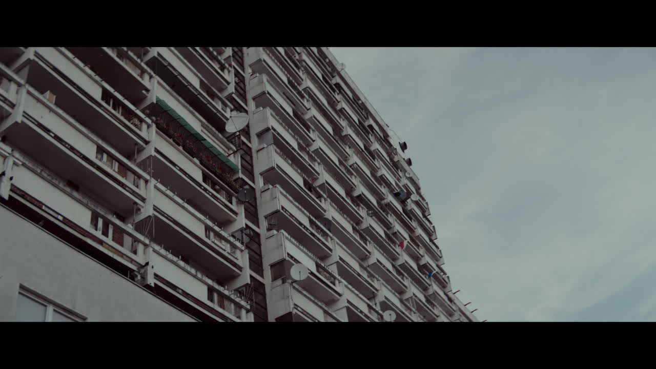 Multi-story Apartment Building with Balconies and Satellite Dishes