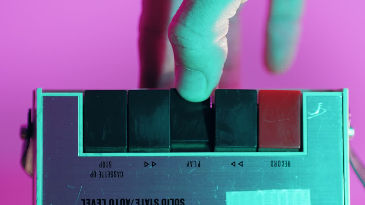 Hand Pressing Buttons on a Vintage Cassette Tape Player