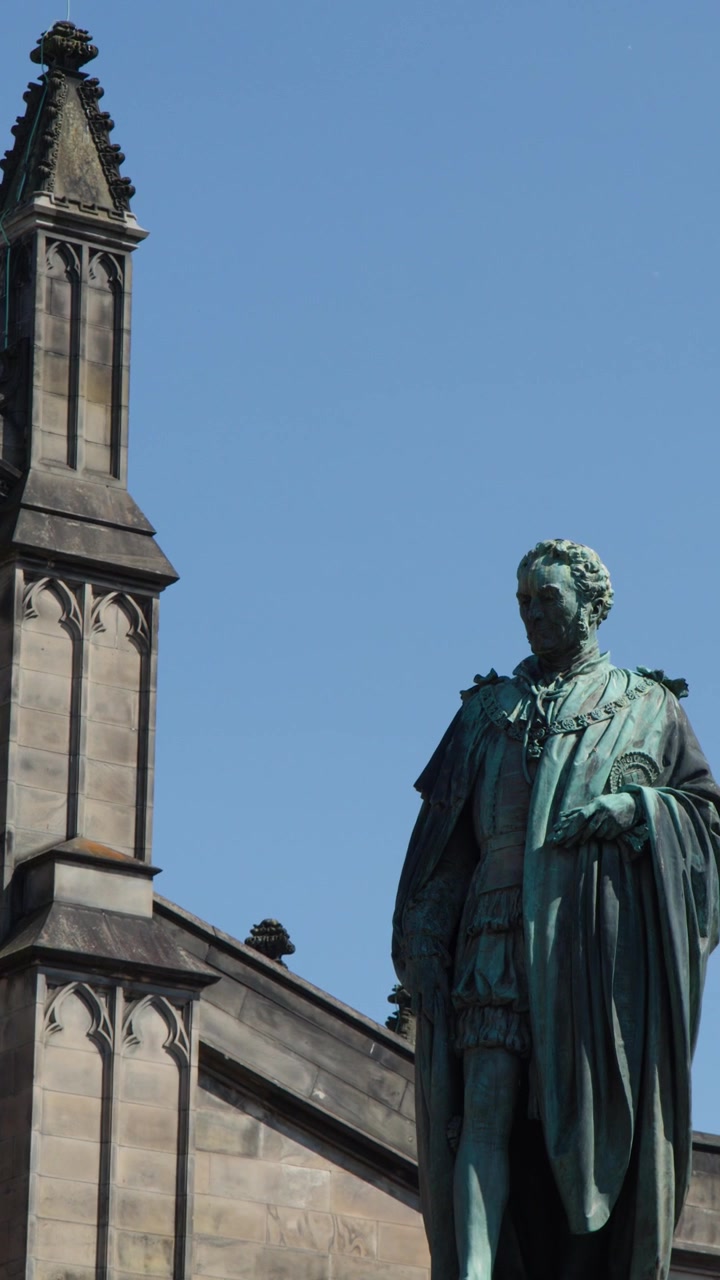 Movimento di telecamera verso il basso che rivela l'architettura di una chiesa gotica e una statua di bronzo sotto un cielo diurno limpido.