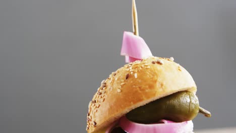 hamburger on wooden board against grey background