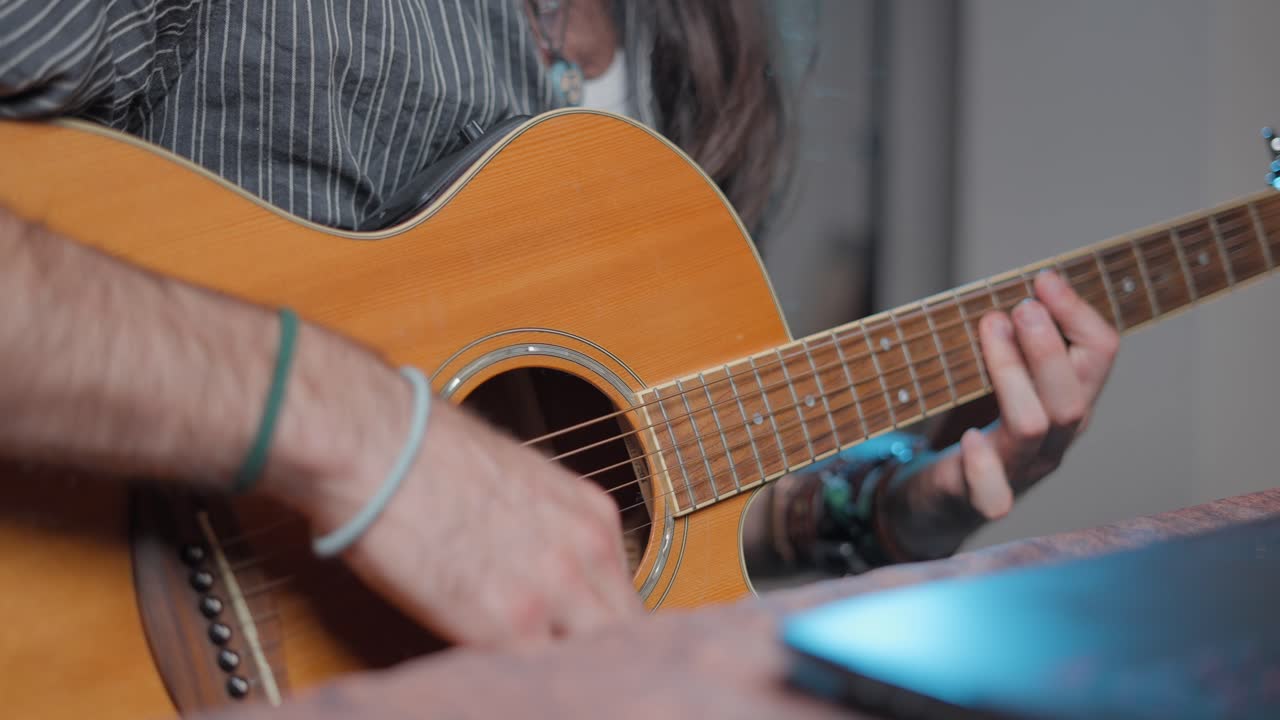 persona que toca la guitarra acústica