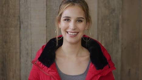 portrait of stylish young woman laughing caucasian female enjoying happy lifestyle wearing red jacket wooden background