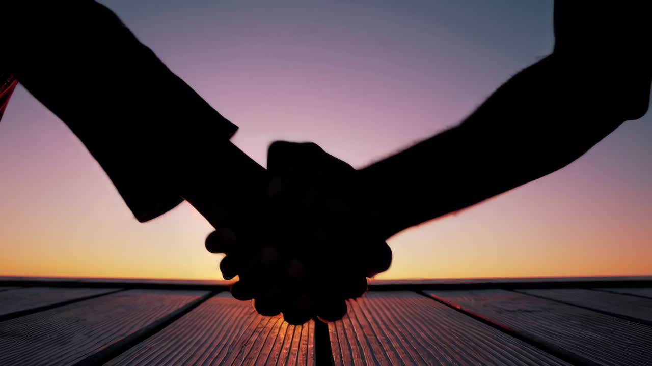 Silhouetted Hands Against Sunset