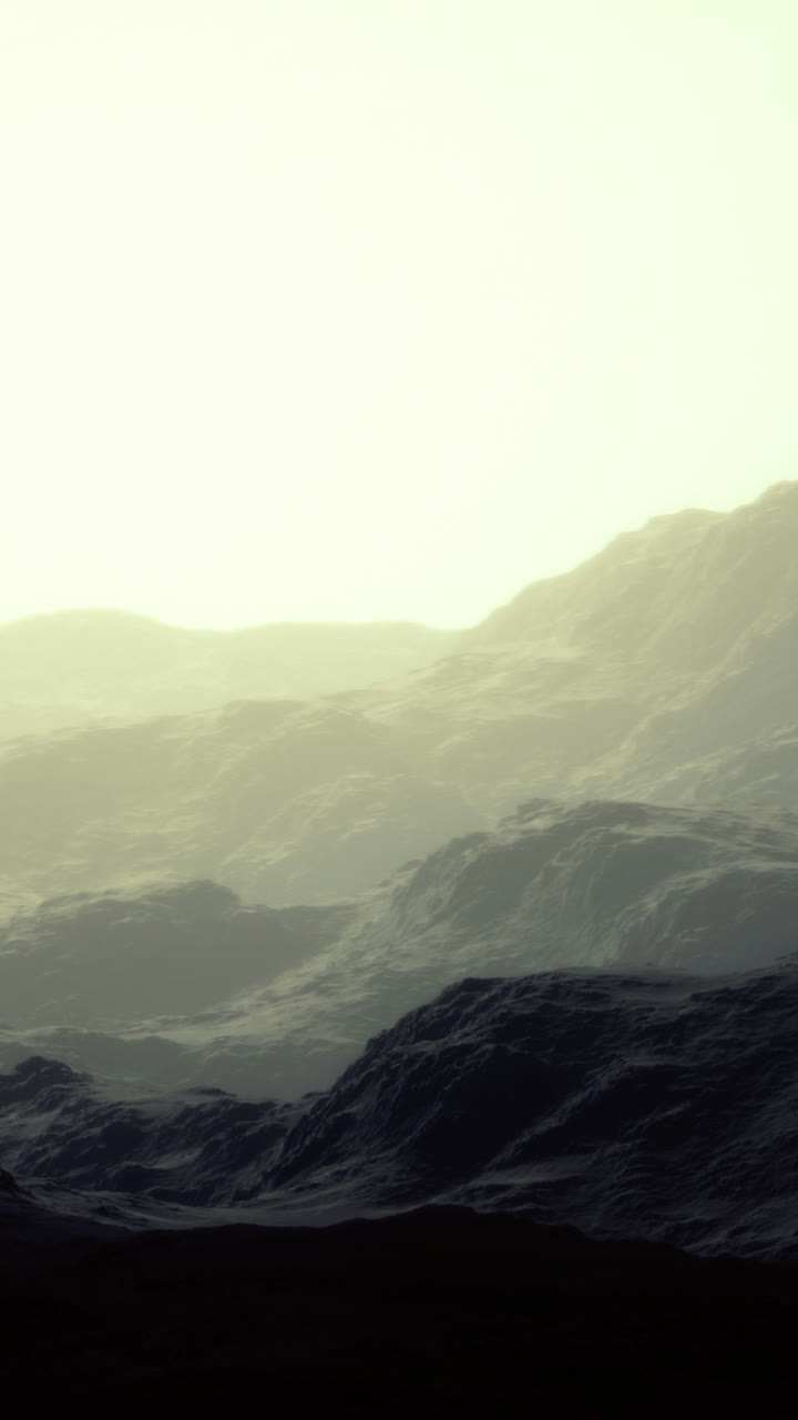 Shadows dance in soft light over rugged mountains at dawn