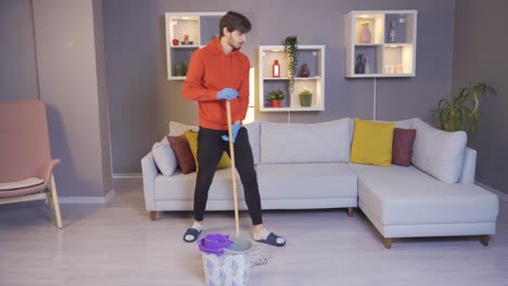 young man cleaning house dancing, making his job fun.