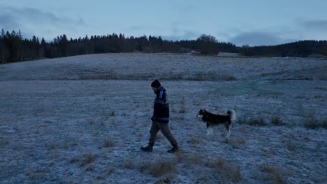 Indre-Fosen,-Kreis-Trondelag,-Norwegen-–-Im-November-Geht-Ein-Mann-Neben-Seinem-Hund-Durch-Den-Bauernhof-–-Kamerafahrt