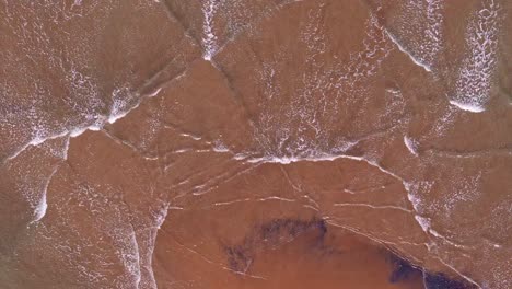 top-down view of gentle waves over tropical sand bar