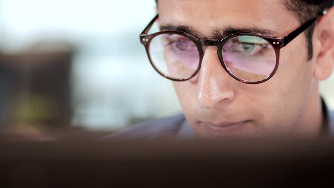 un primer plano de un joven hombre de negocios adulto trabajando en una pantalla de computadora o portátil en un proyecto financiero.