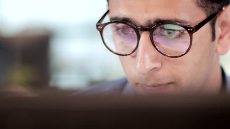 un primer plano de un joven hombre de negocios adulto trabajando en una pantalla de computadora o portátil en un proyecto financiero.