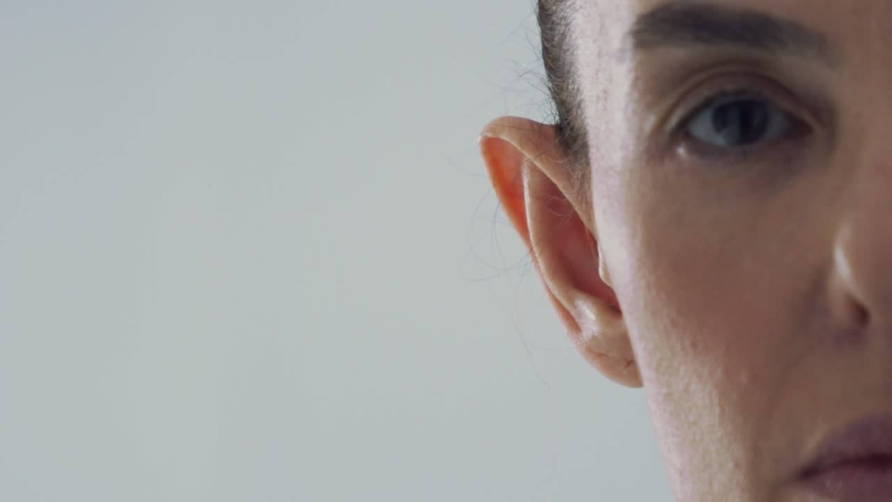 primer plano de una mujer morena de mediana edad dando la vuelta, mirando directamente a la cámara