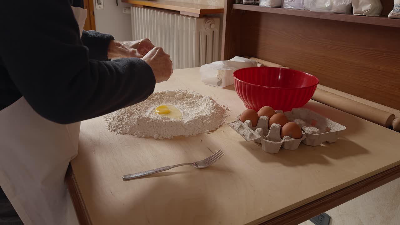 Traditional Romagna cook cracks eggs into flour to prepare fresh cappelletti dough on a wooden table. Authentic Italian pasta-making process in a rustic kitchen