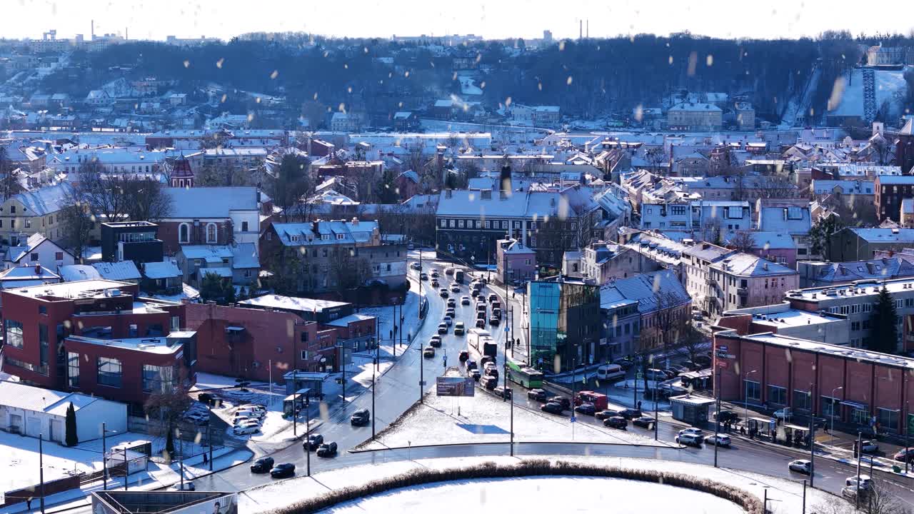 Busy Kaunas city downtown during snowfall, aerial drone view