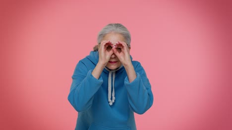 Neugierige-ältere-Oma-Schließt-Die-Augen-Mit-Der-Hand,-Spioniert-Durch-Die-Finger,-Versteckt-Sich,-Guckt