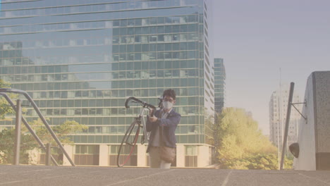 puntos de luz contra el hombre asiático que lleva su bicicleta subiendo las escaleras