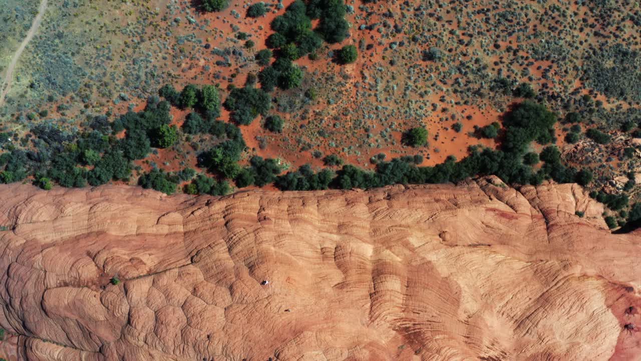 magnífica vista aérea de drones a vista de pájaro de increíbles dunas de arena petrificadas rojas con follaje verde en el desierto del parque estatal snow canyon en el sur de utah