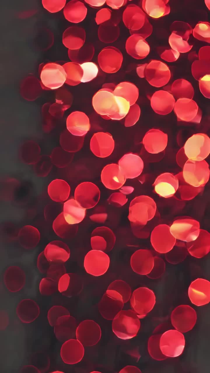 A vertical video showcasing a bokeh effect with red circular lights