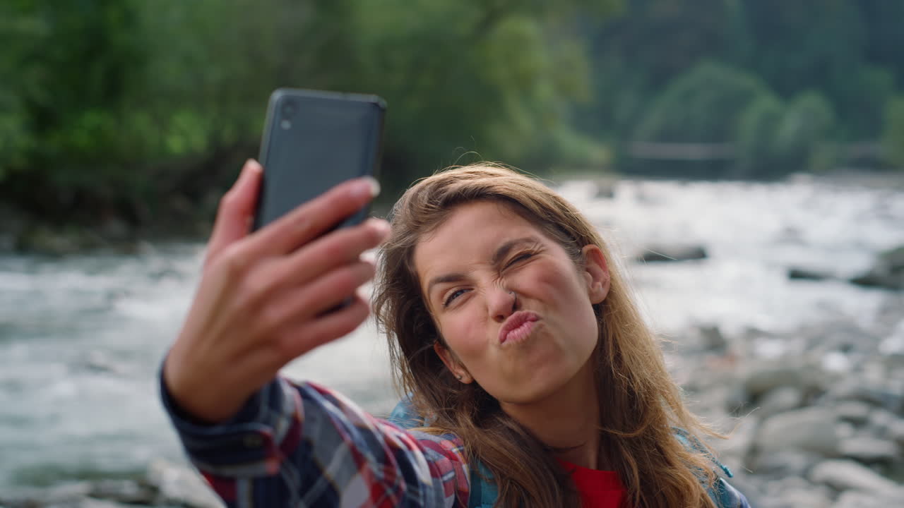 mujer sonriente tomando una selfie en el teléfono inteligente. chica boquiabierta labios en la cámara selfie