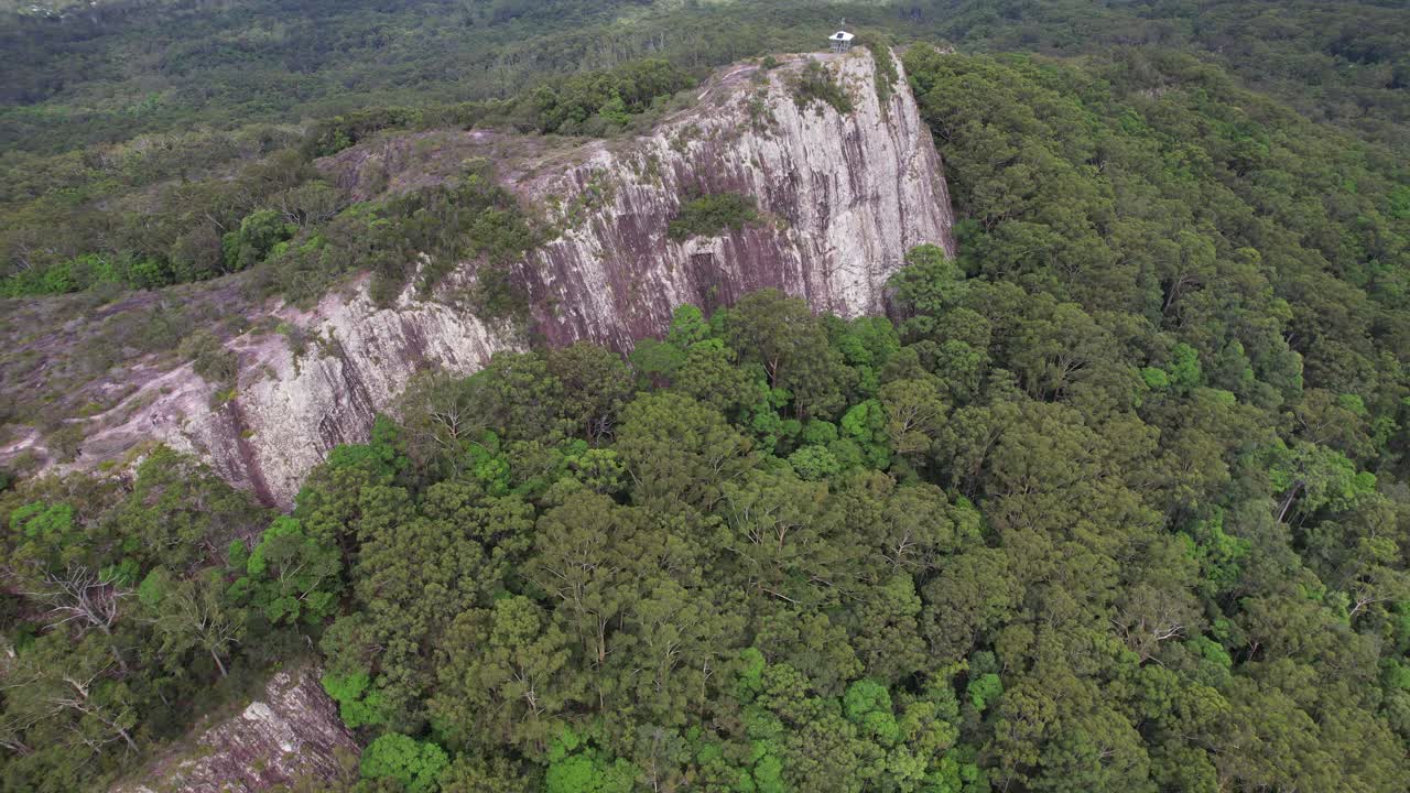 Lush Forest Surrounding Rocky Cliff Of Mount Tinbeerwah Lookout In Queensland, Australia. aerial shot