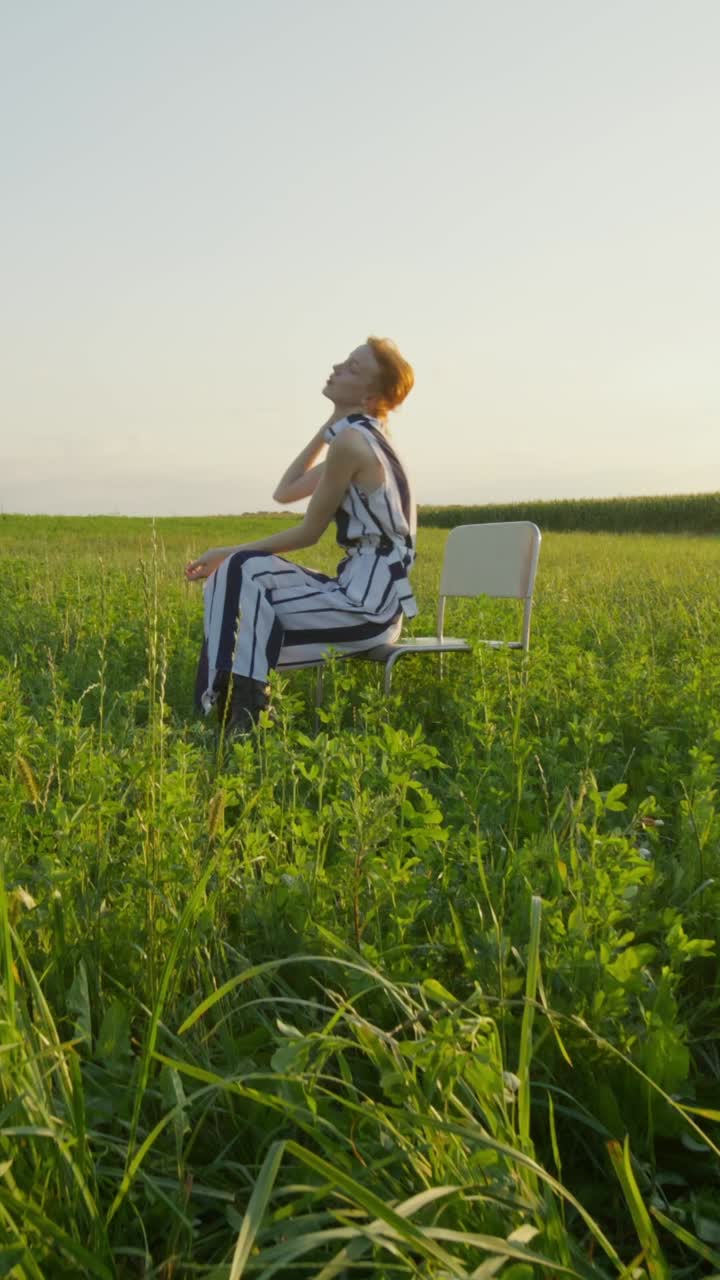 해가 지는 동안 들판에 앉아 있는 여자