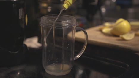 Putting-A-Flavored-Juice-In-The-Blender-Jar-With-A-Lemon-Peel-In-The-Background