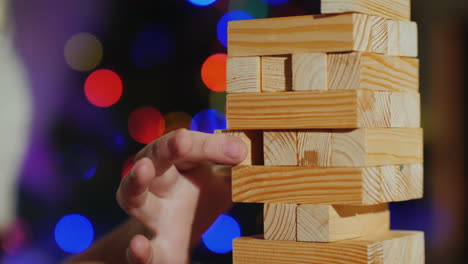 pulling a wooden block out of the tower is a game for training accuracy close-up shot