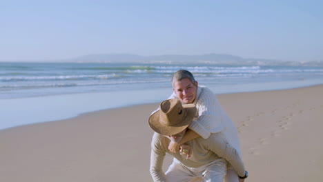 retrato, de, feliz, pareja mayor, teniendo, piggyback, paseo, en, playa