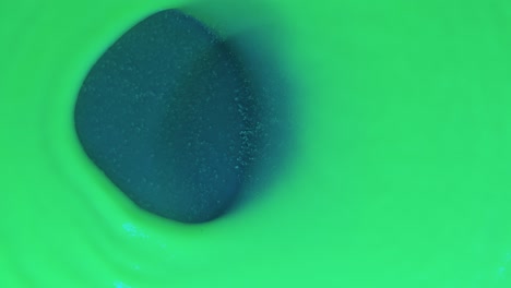 Wind moves the circle of green fluorescent paint horizontally. Top