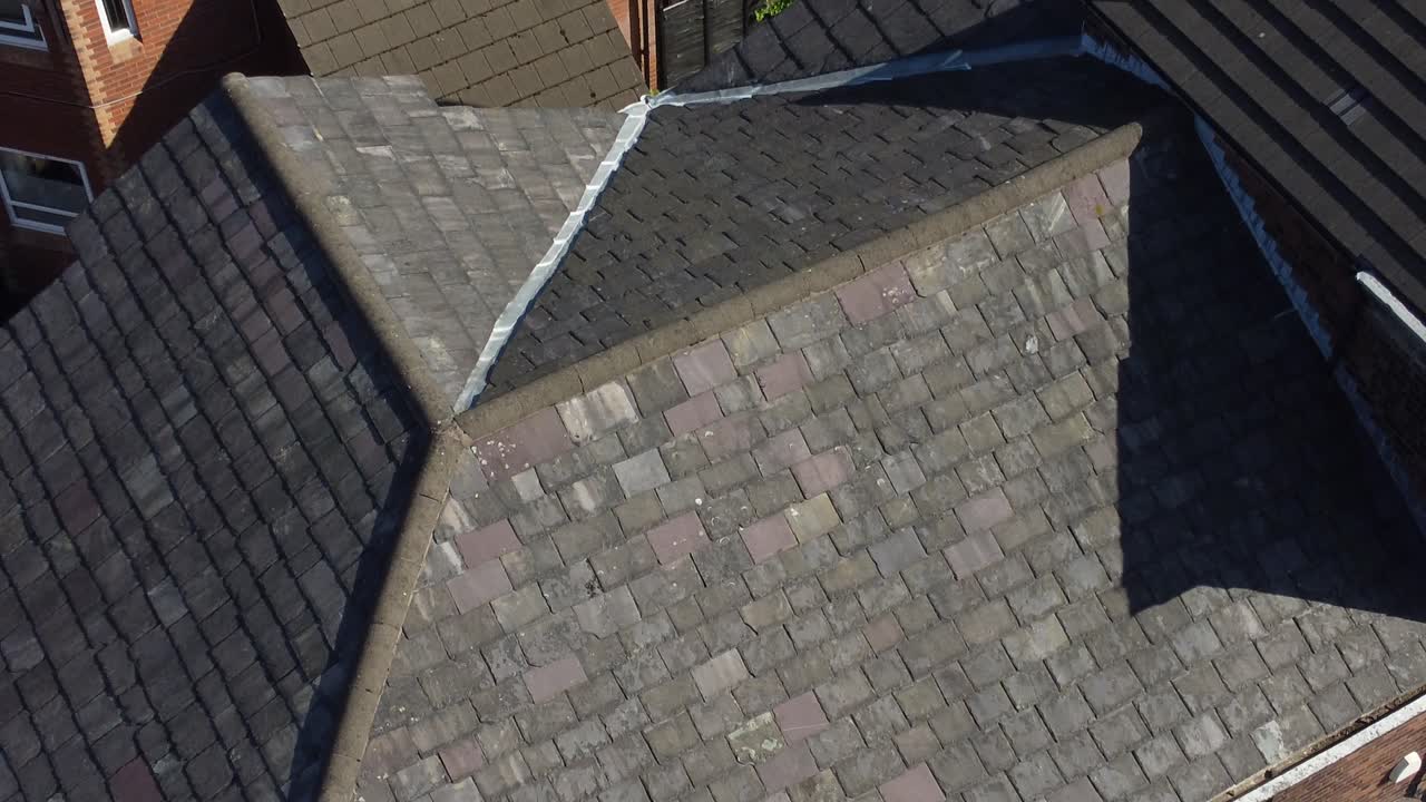 Rooftop analysis aerial view inspecting damage and repair of real estate for homeowner