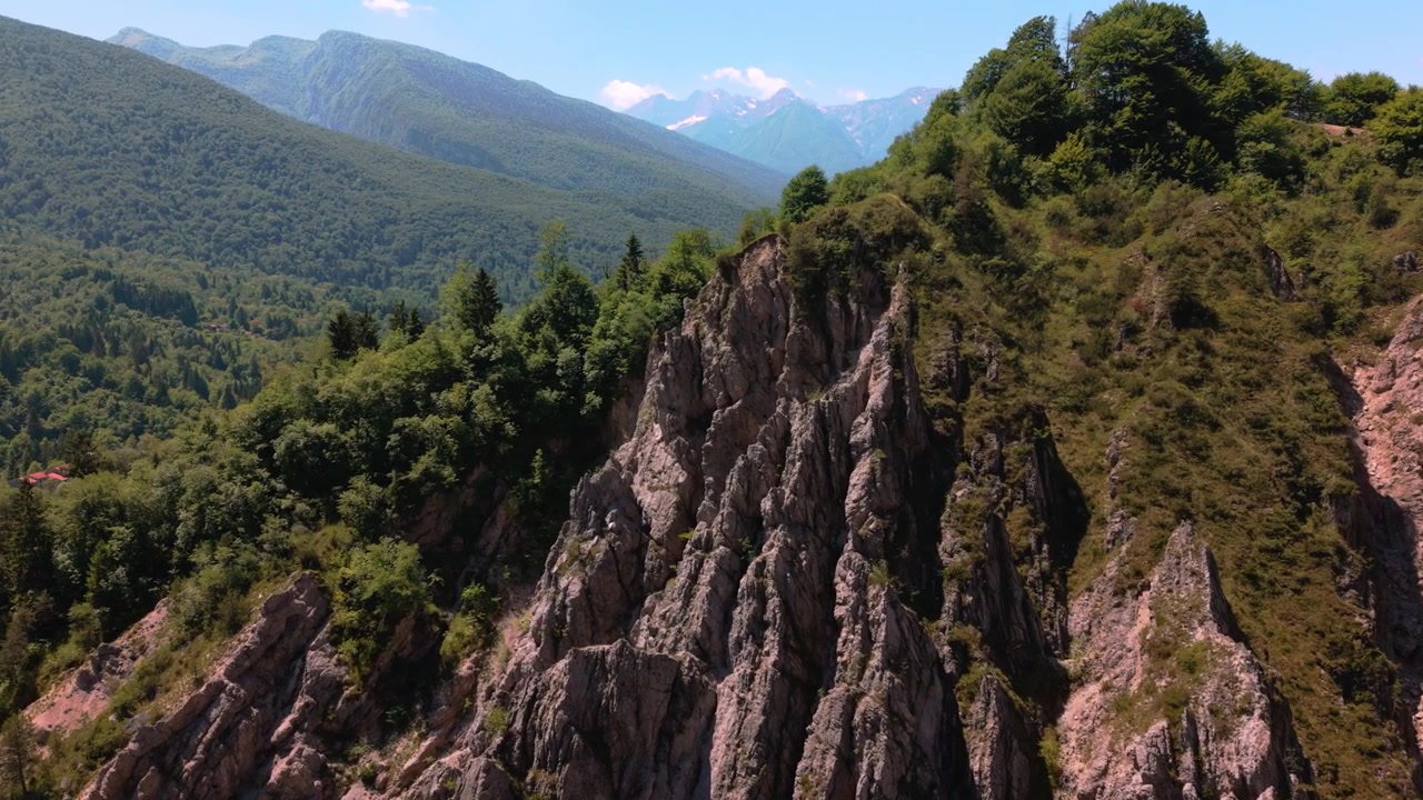 Creste rocciose e affilate delle Dolomiti incorniciate da ripidi pendii verdi vicino al Lago di Barcis, Italia. Montagna drammatica.