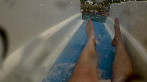 first person shot of a man going down a water park slide before plunging underwater