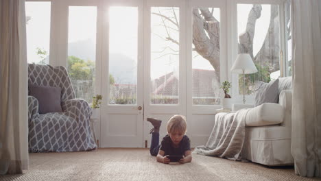 little boy using smartphone playing games relaxing lying on floor at home child browsing online with mobile phone technology anti social addiction concept 4k footage